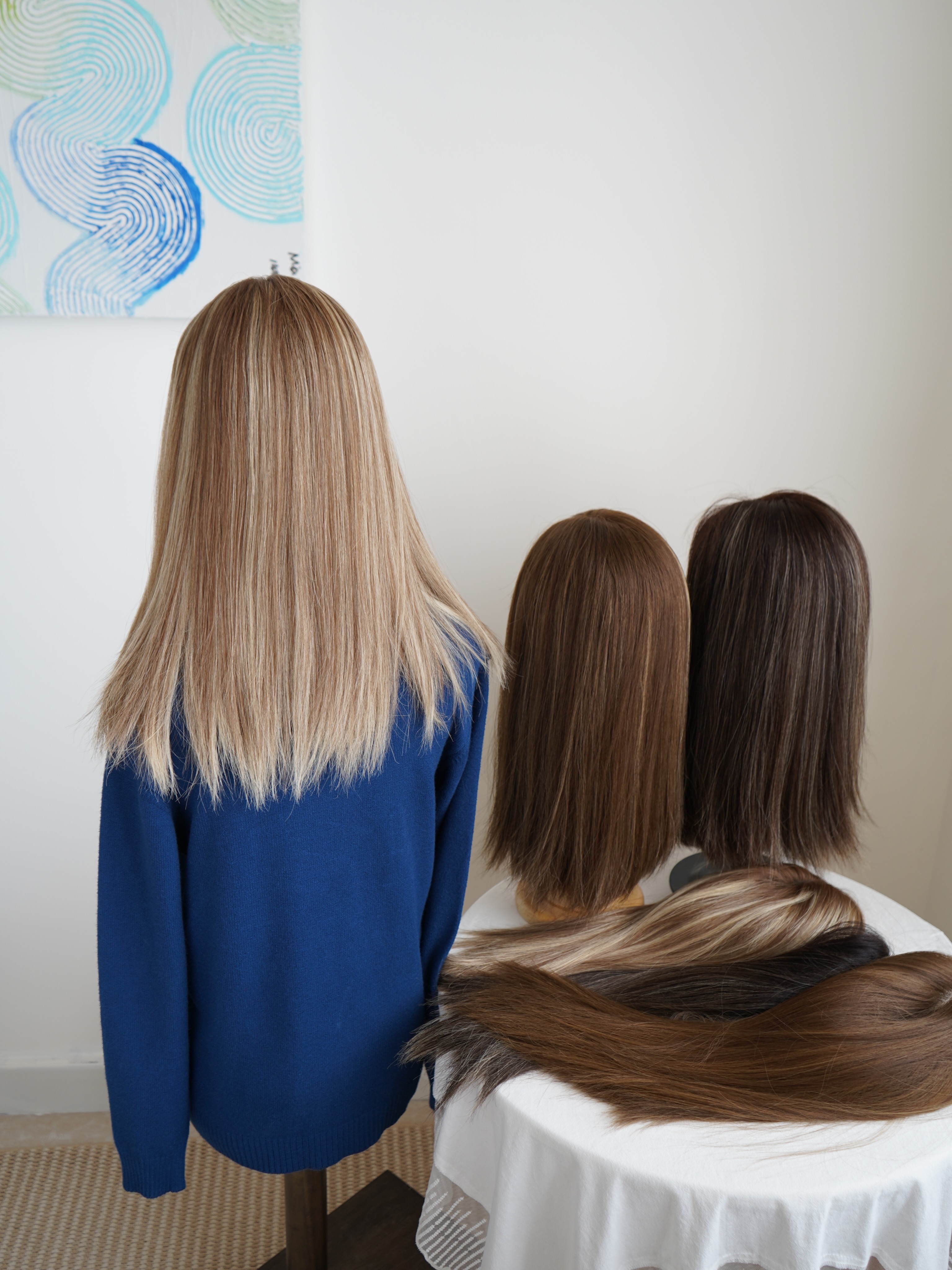 Long, finished human-hair wig shown from the back beside a lace detail sample